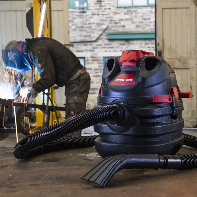 a red and black shop-vac hawkeye builders vacuum cleaner being used in a workshop