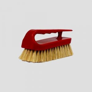 a red tampico scrubbing brush on a grey background
